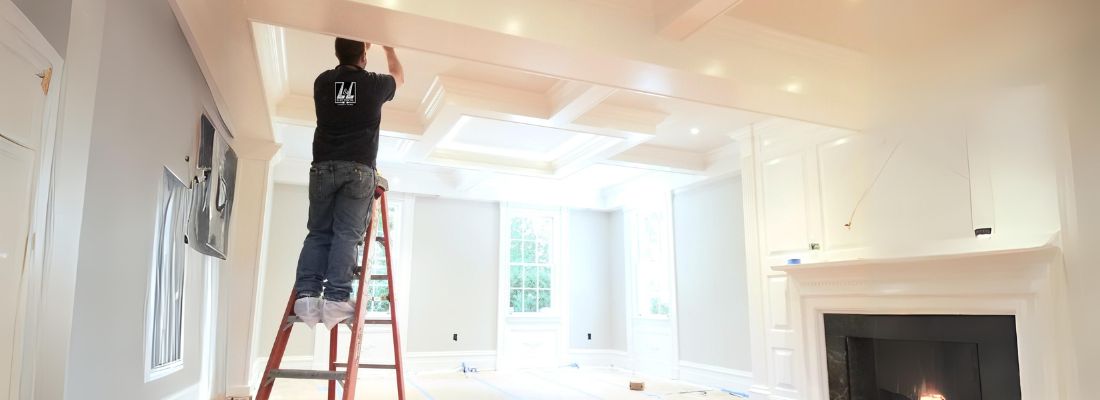 Electrician installing recessed ceiling lighting in a modern residential living room during a home renovation project.