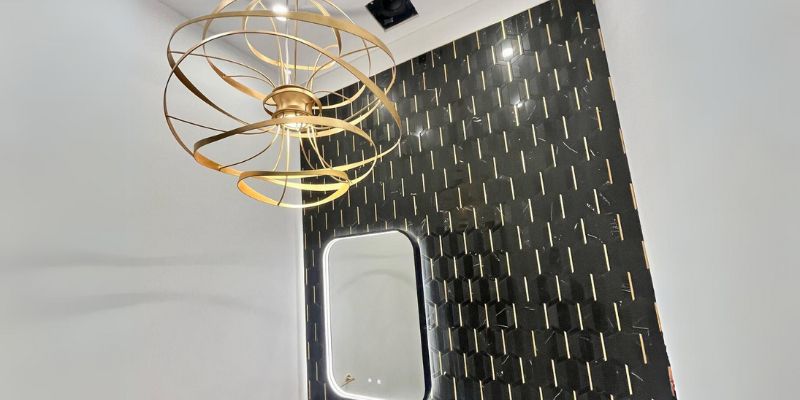 Decorative modern chandelier and accent lighting installed in a luxury interior space with stylish wall finishes and contemporary design.
