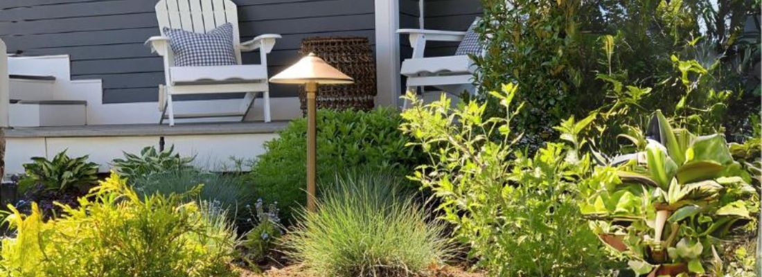 Residential outdoor landscape lighting illuminating a front porch and garden, enhancing curb appeal, safety, and exterior home design.
