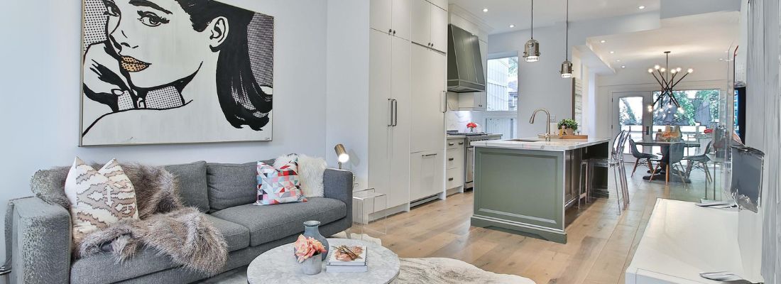 Modern open-concept living room and kitchen with stylish lighting, contemporary furnishings, and residential interior electrical design.