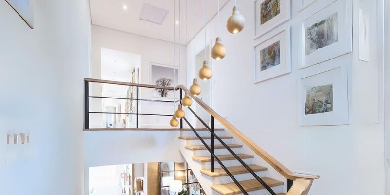 Contemporary staircase with hanging pendant lights and modern interior lighting design in a residential home.
